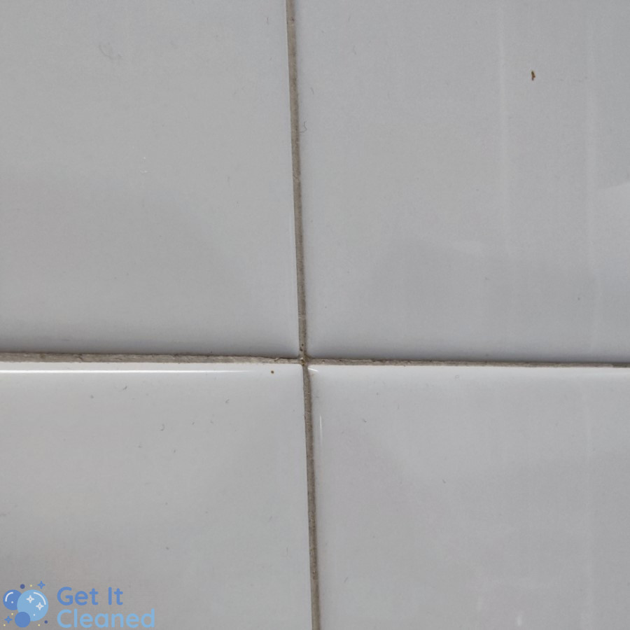 Dirty grout between white tiles