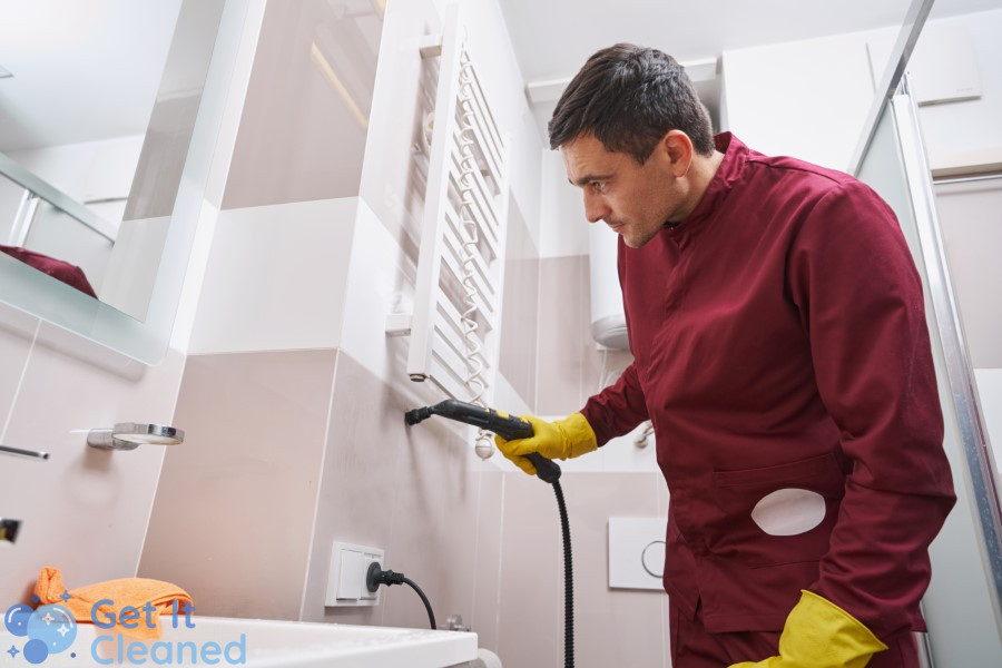 A Professional cleaner steam cleaning tile grout in a bathroom